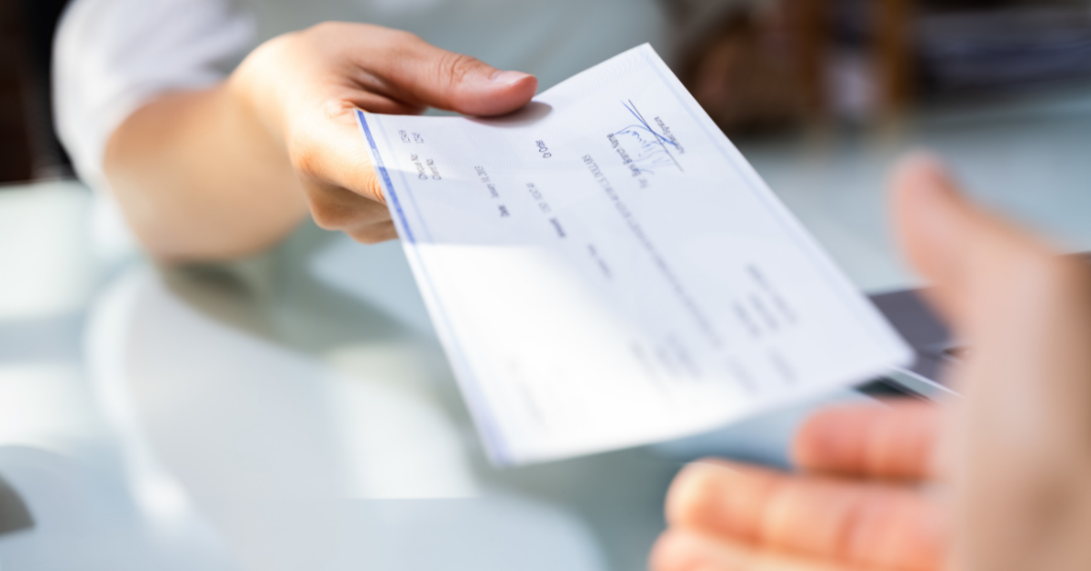payroll handing a check to an employee